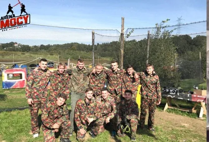 Grupa przyjacół na wieczorze kawalerskim z paintballem